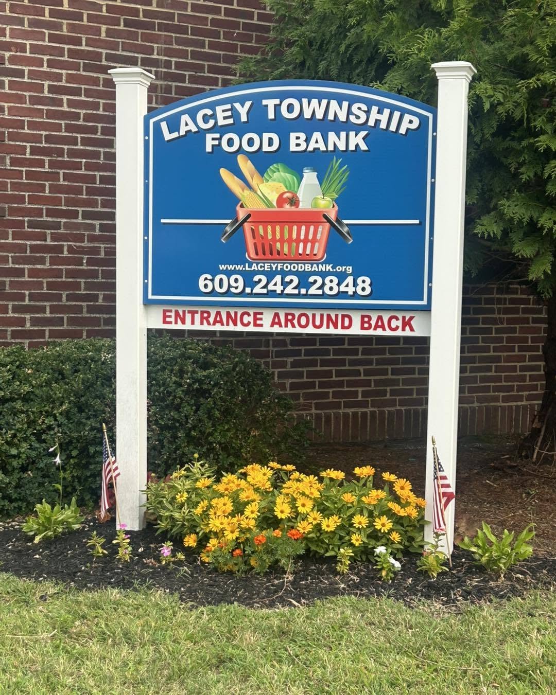 Sign in Front of the Lacey Food Bank with fresh flowers planted beneath the sign.